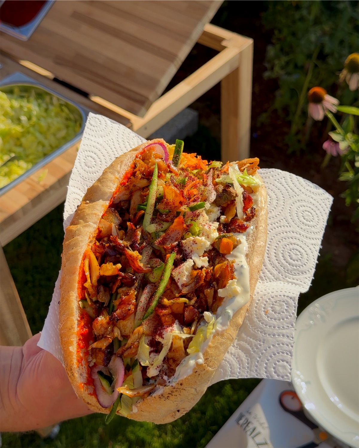 ALMANS Döner mit Chicken, Grillgemüse, Weichkäse, Soßen und Sumach im Abendlicht